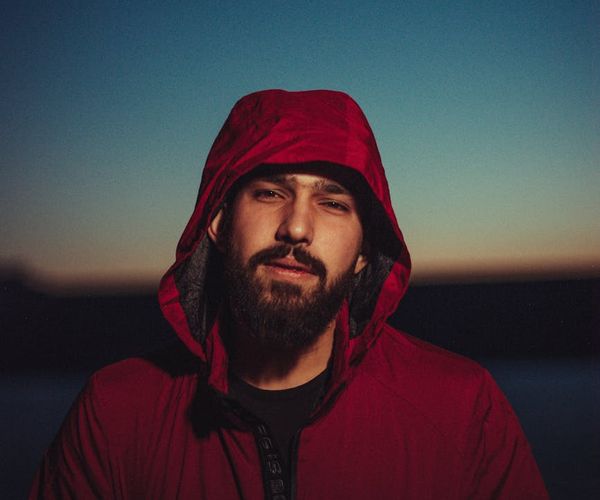 A silhouette of a person standing peacefully against a red-toned background.