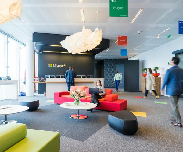 Person performing a light leg swing in a spacious, modern room.