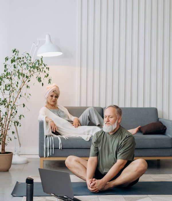 Woman in a calm stretching pose in a softly lit room.